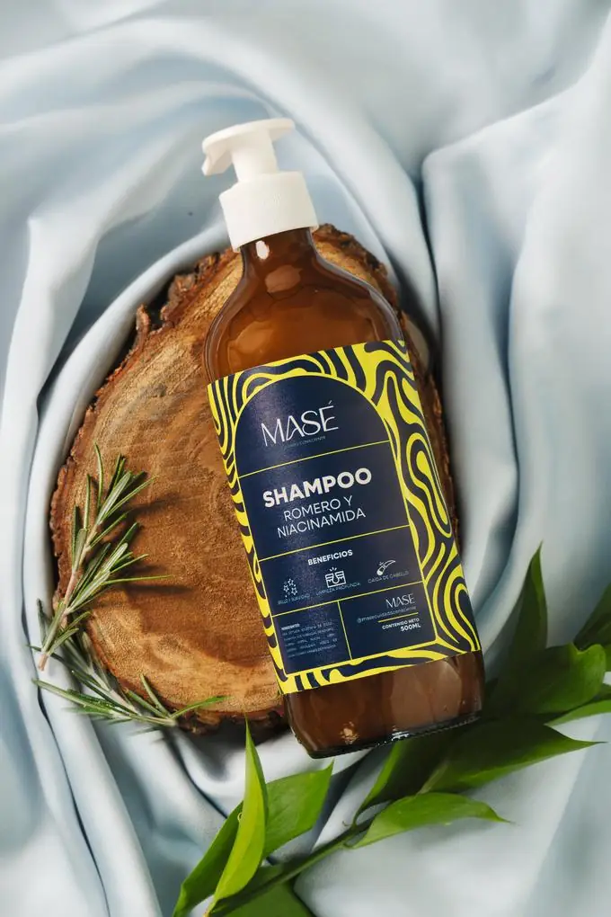 Shampoo MASÉ Romero y Niacinamida, botella de 500ml sobre madera y tela