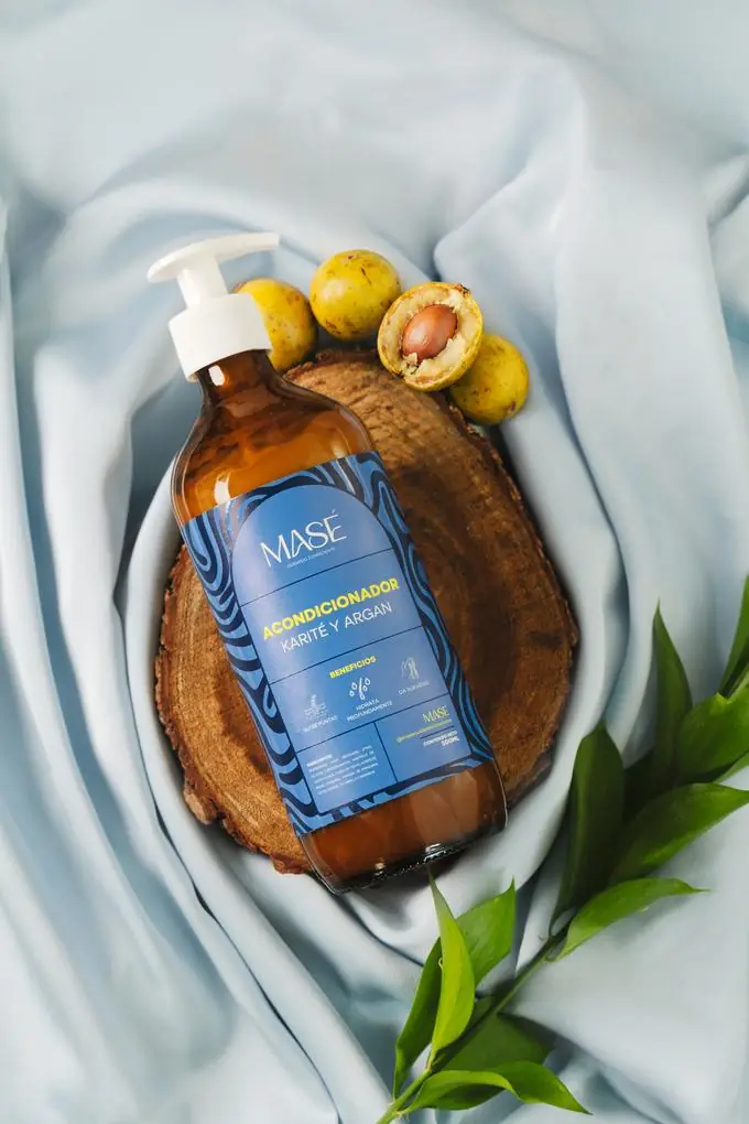 Acondicionador MASÉ Karité y Argán, botella de 500ml sobre madera y tela
